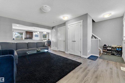 Wood-finish flooring, recessed lighting, white interior doors, and staircase with white railing - #22 4205 30 St Nw, Edmonton, AB 