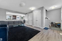 Wood-finish flooring, recessed lighting, white interior doors, and staircase with white railing - 