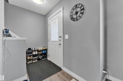 Entryway featuring a white door with frosted glass paneling, wood-finish flooring, and a flush-mount ceiling light - 