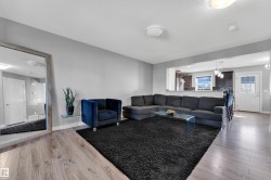 Open-concept living area with wood-finish flooring, light gray walls, and recessed lighting - 