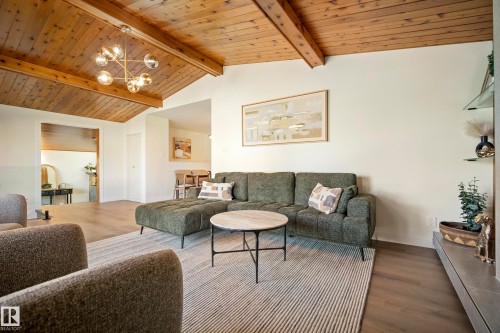 Vaulted wood-paneled ceiling with exposed beams, contemporary ceiling light fixture, wood-finish flooring, and built-in wall shelving - 10316 42 Street Nw, Edmonton, AB 