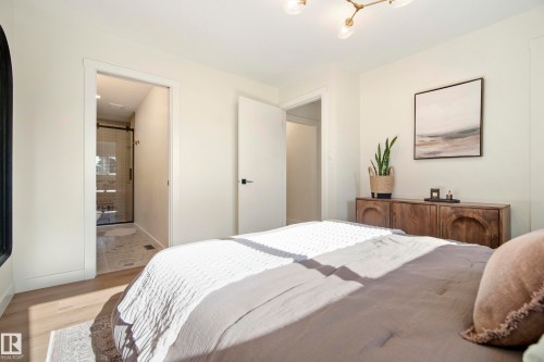 Light wood-finish flooring with a subtle area rug - 10316 42 Street Nw, Edmonton, AB 