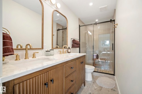 Dual vanity with gold-finish fixtures and arched mirrors - 10316 42 Street Nw, Edmonton, AB 