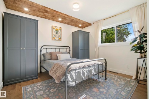 Wood-finish flooring, recessed lighting, and a white ceiling with a wood-clad beam - 10316 42 Street Nw, Edmonton, AB 