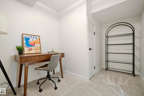 Neutral wall paint, light-colored carpeting, white trim, and a white door with black hardware - 10316 42 Street Nw, Edmonton, AB 