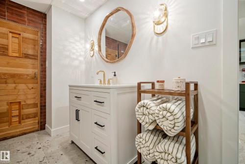 White vanity with cabinet storage, brass-finish faucet, and a contemporary mirror - 10316 42 Street Nw, Edmonton, AB 