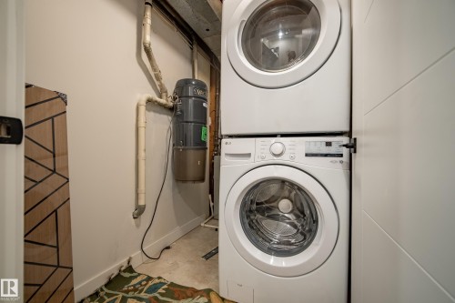 Stackable washer and dryer appliances within a dedicated utility area - 10316 42 Street Nw, Edmonton, AB 