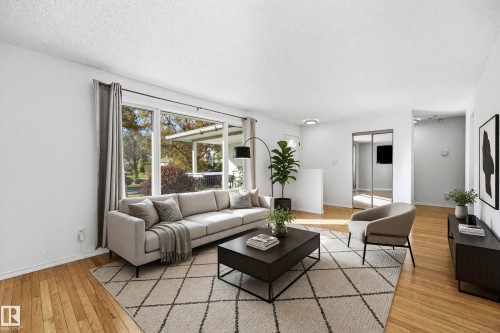 Hardwood-finish flooring, expansive picture window, white walls, recessed lighting, and mirrored closet doors - 74 Aspen Crescent, St. Albert, AB 