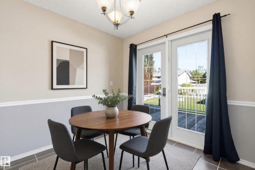 French doors with divided lites, a multi-paneled ceiling light fixture, and a two-tone wall finish with chair rail molding - 74 Aspen Crescent, St. Albert, AB 