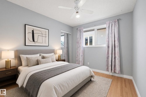 Light gray wall paint, wood-finish flooring, white ceiling fan, large window with white trim, and a full-length mirror - 74 Aspen Crescent, St. Albert, AB 