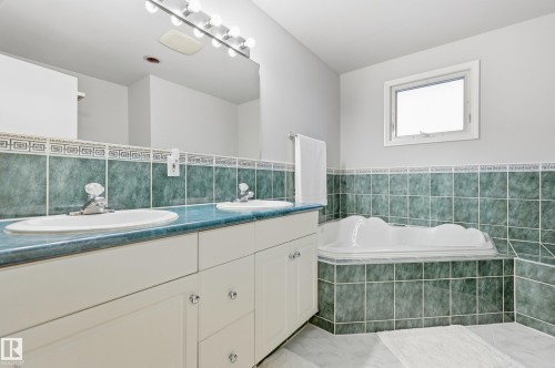 Dual vanity with undermount sinks, integrated countertop, and wall-mounted mirror - 74 Aspen Crescent, St. Albert, AB 