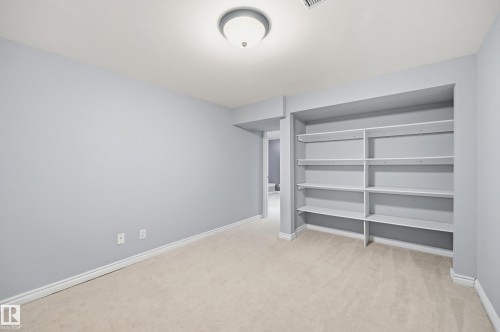 Recessed built-in shelving, neutral-toned carpeting, and a flush-mount ceiling light - 74 Aspen Crescent, St. Albert, AB 