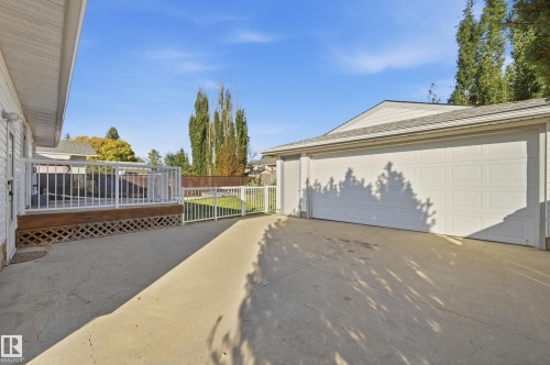 Spacious concrete driveway leading to a multi-car garage with panel doors - 74 Aspen Crescent, St. Albert, AB 