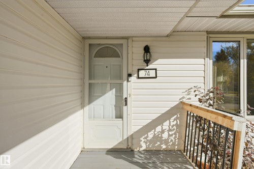 White vinyl siding exterior with a dark-framed window - 74 Aspen Crescent, St. Albert, AB 