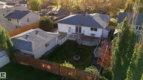 Exterior featuring a multi-level deck, expansive green space, detached garage, and a fire pit - 74 Aspen Crescent, St. Albert, AB 