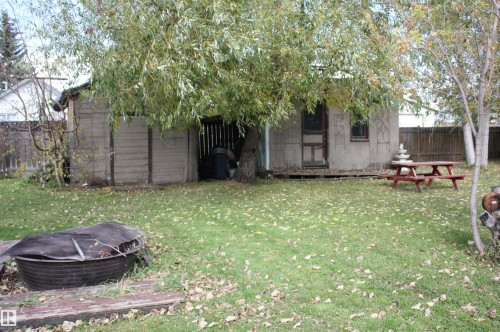 Expansive green lawn with mature trees and a privacy fence - 5012 49 Ave, Radway, AB 