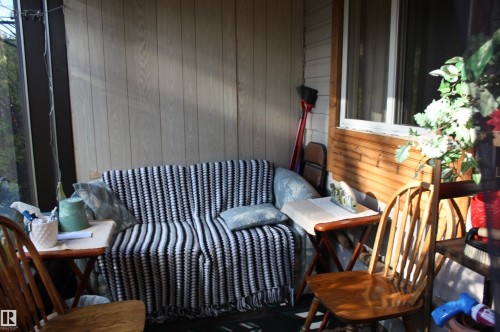 Enclosed porch featuring vertical wood paneling and horizontal wood siding - 5012 49 Ave, Radway, AB 