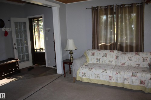 Entryway featuring a multi-pane glass door and wood-finish ceiling detailing - 5012 49 Ave, Radway, AB 
