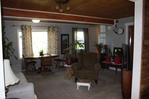 Tongue-and-groove wood-plank ceiling, exposed structural wood beam, and expansive windows - 5012 49 Ave, Radway, AB 