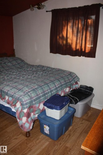 Room featuring wood-finish flooring and a multi-directional ceiling-mounted light fixture - 5012 49 Ave, Radway, AB 