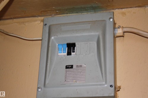 Surface-mounted electrical service panel with four individual circuit breakers and a designated directory label - 5012 49 Ave, Radway, AB 