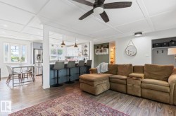 Coffered ceiling details, wood-finish flooring, recessed lighting, and a kitchen island with seating - 
