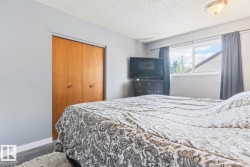 Wood-finish flooring, light gray wall paint, and a built-in closet with natural wood doors - 