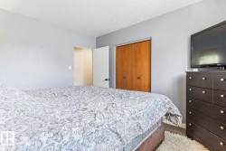 Neutral wall tones, wood-finish flooring, and a built-in closet with double wood doors - 