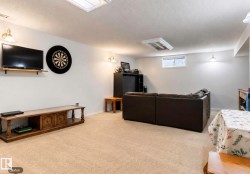 Carpeted room with recessed lighting and wall sconces, featuring a window and a built-in wall shelf - 