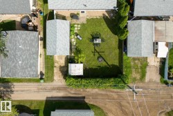 Expansive backyard featuring a green lawn, established privacy hedges, and a fire pit area - 