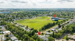 Suburban neighborhood with mature tree-lined streets, a large green space, and a community building - 