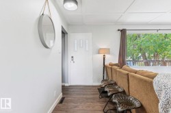 Wood-finish flooring, white paneled ceiling, and a large window providing ample natural light - 