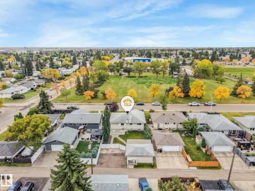Property featuring a pitched roof, front yard, established trees, and a concrete driveway - 5904 94 Avenue Nw, Edmonton, AB 