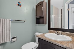 Vanity with an integrated sink and light-toned countertop, framed mirror, and wall-mounted storage cabinet - 