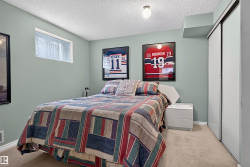 Recessed window, textured ceiling, sliding closet doors, built-in overhead bulkhead, and ceiling-mounted light fixture - 1519 104 Street Nw, Edmonton, AB 