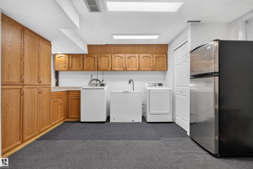 Extensive built-in wood cabinetry, light countertops, and durable flooring create a functional space - 1519 104 Street Nw, Edmonton, AB 