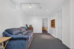Recessed lighting, track lighting, carpet flooring, white paneled door, built-in wooden shelving - 