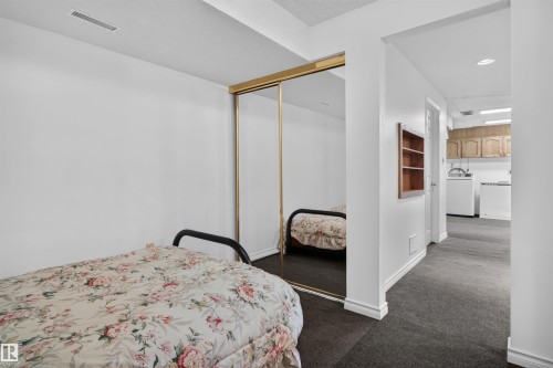 Built-in mirrored closet doors, recessed lighting, and dark carpet flooring - 1519 104 Street Nw, Edmonton, AB 