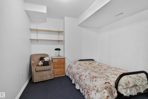 Wall-mounted shelving system, dark carpeting, and white walls - 1519 104 Street Nw, Edmonton, AB 