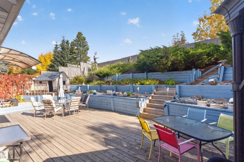 Expansive wood deck with tiered landscaping and integrated garden beds - 1519 104 Street Nw, Edmonton, AB 