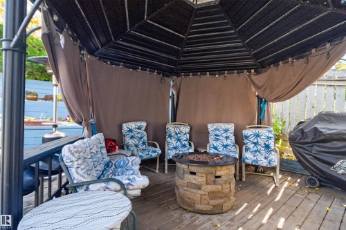 Expansive outdoor deck featuring a gazebo, stone-clad fire pit, and wood plank flooring - 1519 104 Street Nw, Edmonton, AB 