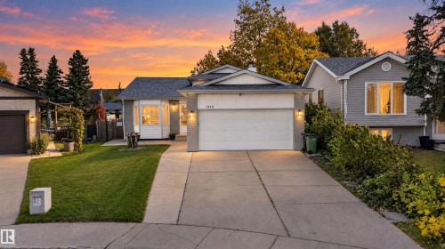Architectural shingle roofing, attached garage, concrete driveway, bay window, and exterior wall sconces - 1519 104 Street Nw, Edmonton, AB 