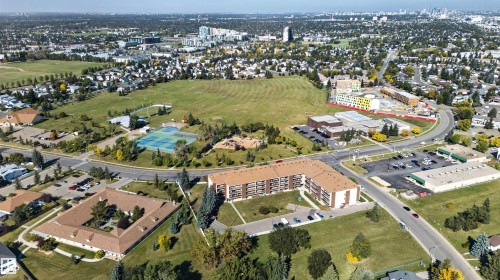 Expansive suburban landscape with varied residential structures, abundant green spaces, a commercial building complex, and multiple roadways - 1519 104 Street Nw, Edmonton, AB 