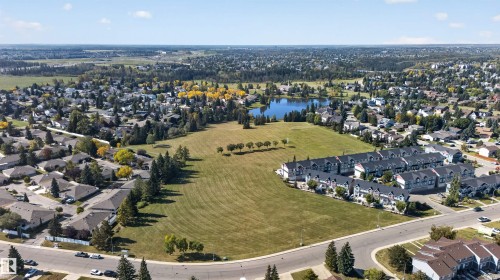 Expansive open field with surrounding residential properties, mature trees, and a lake - 1519 104 Street Nw, Edmonton, AB 