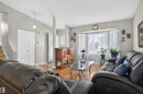 Recessed bay window, wood-finish flooring, light grey wall paint, white trim, and a contemporary pendant light fixture - 1519 104 Street Nw, Edmonton, AB 