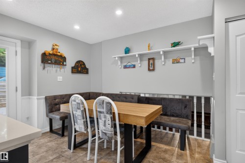 Recessed ceiling lighting, tiled flooring, built-in corner seating, wood-finish table, and white painted wainscoting - 1519 104 Street Nw, Edmonton, AB 