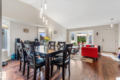 Vaulted ceiling with linear pendant lighting, wood-finish flooring, and bay windows - 4103 44 Avenue, Stony Plain, AB 