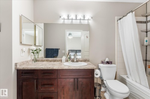 Vanity with dark wood-finish cabinetry, white drop-in basin, and a light-toned countertop - 4103 44 Avenue, Stony Plain, AB 