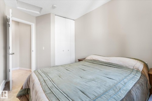 Built-in bi-fold closet doors, neutral wall paint, and carpet flooring - 4103 44 Avenue, Stony Plain, AB 