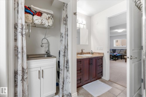 Laundry area with a utility sink and white cabinetry - 4103 44 Avenue, Stony Plain, AB 